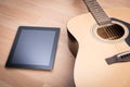 Acoustic guitar with digital tablet Royalty Free Stock Photo