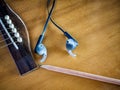 Acoustic guitar with earphone and pencil Royalty Free Stock Photo