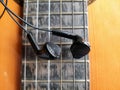 Acoustic Guitar and earphones. Retro style guitar and a earphones. Royalty Free Stock Photo