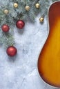 Acoustic guitar and  fir tree branches with red and golden Christmas  balls on light  background Royalty Free Stock Photo