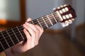 Acoustic guitar fretboard with Caucasian female long fingers hand striking a chord Royalty Free Stock Photo