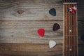 An acoustic guitar fretboard and some guitar picks on wooden table Royalty Free Stock Photo