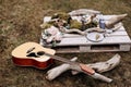 Acoustic guitar on the grass against the background of a wooden stand with items for decoration. Royalty Free Stock Photo