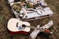 Acoustic guitar on the grass and flowers, a tree branch and candles on a wooden stand. Royalty Free Stock Photo