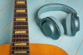 Acoustic guitar and green headphones on wooden background closeup Royalty Free Stock Photo