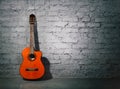 Acoustic guitar leaning on grungy wall Royalty Free Stock Photo