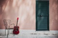 acoustic guitar lying in front of the house with empty chair, vintage style with copy space