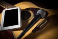 Acoustic guitar with microphone and computer tablet. Royalty Free Stock Photo