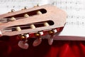 Acoustic guitar and music notes on red velvet fabric, close view of objects Royalty Free Stock Photo