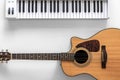 Acoustic guitar and musical keys on a white background, flat lay. Royalty Free Stock Photo