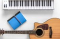 Acoustic guitar and musical keys on a white background, flat lay. Royalty Free Stock Photo