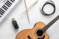 Acoustic guitar and musical keys on a white background, flat lay. Royalty Free Stock Photo