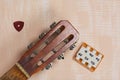 Acoustic guitar neck, tuning fork and pick. Against a background painted in white and beige Royalty Free Stock Photo