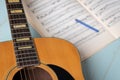 Acoustic guitar pencil and music sheets on wooden background Royalty Free Stock Photo