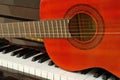 Acoustic guitar on piano keyboard Royalty Free Stock Photo