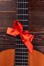 Acoustic guitar with red bow.