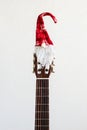 acoustic guitar with red Santa hat. Christmas song music concept on white background Royalty Free Stock Photo