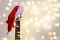 Acoustic Guitar with red Santa hat and light garland. Christmas music song concept with copyspace Royalty Free Stock Photo