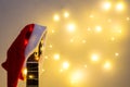 Acoustic Guitar with red Santa hat and light garland. Christmas music song concept with copyspace Royalty Free Stock Photo