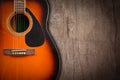 Acoustic guitar resting against a blank grunge background with c. Royalty Free Stock Photo