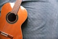 Acoustic guitar resting against a fabric background