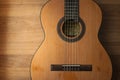 Acoustic guitar resting against a wooden background