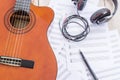 Acoustic guitar, sheet music, big earphone, fountain pen on wood Royalty Free Stock Photo