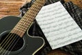 Acoustic guitar and sheet musical notes on the table. Royalty Free Stock Photo