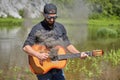 The guitarist uses a smoking guitar in nature