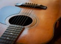 Acoustic guitar. Top view for part of neck and body with wooden top, sound hole, strings and bridge pins. Royalty Free Stock Photo