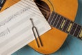 Acoustic guitar tuning fork and music sheets close up Royalty Free Stock Photo