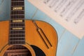 Acoustic guitar tuning fork and music sheets on wooden background Royalty Free Stock Photo