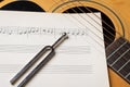 Acoustic guitar tuning music sheets and tuning fork close up Royalty Free Stock Photo