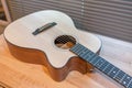 Acoustic guitar on wooden table in the room,Travel accessories concept Royalty Free Stock Photo