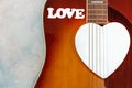 Acoustic guitar, wooden white heart shape symbol and word LOVE on sky blue background. Top view, close up, copy space Royalty Free Stock Photo