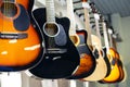 Acoustic guitars of different colors and types on a musical instrument store window. Foreground. Selective focus Royalty Free Stock Photo