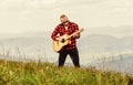 Acoustic music. Keep calm and play guitar. Man hiker with guitar on top of mountain. Hiker enjoy nature. Musician hiker Royalty Free Stock Photo