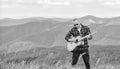 Acoustic music. Musician hiker find inspiration in mountains. Keep calm and play guitar. Man with guitar on top of Royalty Free Stock Photo