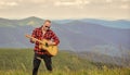 Acoustic music. Musician hiker find inspiration in mountains. Keep calm and play guitar. Man with guitar on top of Royalty Free Stock Photo