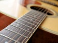 Acoustic wood guitar close up on wooden background with fretboard, strings, and tuners for music blogs, musician social media. Royalty Free Stock Photo