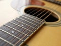 Acoustic wood guitar close up on wooden background with fretboard, strings, and tuners for music blogs, musician social media.