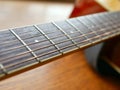 Acoustic wood guitar close up on wooden background with fretboard, strings, and tuners for music blogs, musician social media. Royalty Free Stock Photo