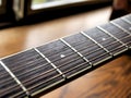 Acoustic wood guitar close up on wooden background with fretboard, strings, and tuners for music blogs, musician social media. Royalty Free Stock Photo