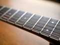 Acoustic wood guitar close up on wooden background with fretboard, strings, and tuners for music blogs, website banners. Royalty Free Stock Photo