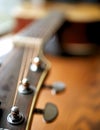 Acoustic wood guitar close up on wooden background with fretboard, strings, and tuners for music blogs, website banners. Royalty Free Stock Photo