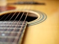 Acoustic wood guitar close up on wooden background with fretboard, strings, and tuners for music blogs, website banners. Royalty Free Stock Photo