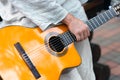 Acoustic yellow classical guitar in a man`s hand Royalty Free Stock Photo