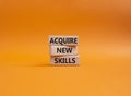 Acquire new skills symbol. Concept words Acquire new skills on wooden blocks. Beautiful orange background. Business and Acquire