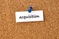 Acquisition. Word written on a piece of paper, cork board background Royalty Free Stock Photo