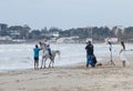 Photographer photographs as an instructor trains a young man to ride a horse on the Mediterranean coast near the city Ako in Israe